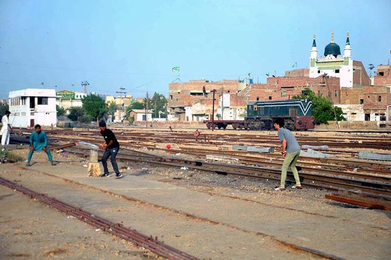 Youth Play Cricket Near Railway Station